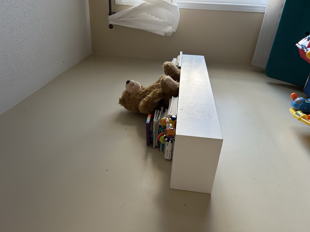 Custom reinforced floating shelf in child's bedroom with books and stuffed bear - Ottawa Handiman