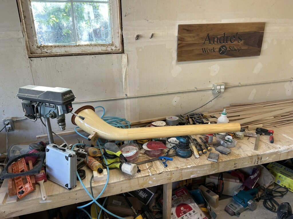 Wooden German hunting horn under repair on the workbench at Ottawa Handiman's Barrhaven workshop